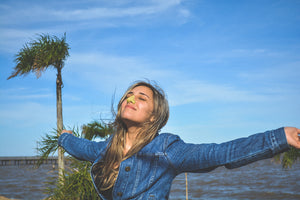 Woman enjoying weather while wearing Nöz Zinc Oxide sunscreen in color yellow.